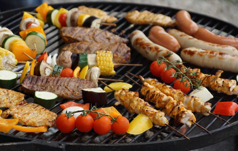 Caja de madera con varios cortes crudos de carne y papel manteca, lista para parrillada